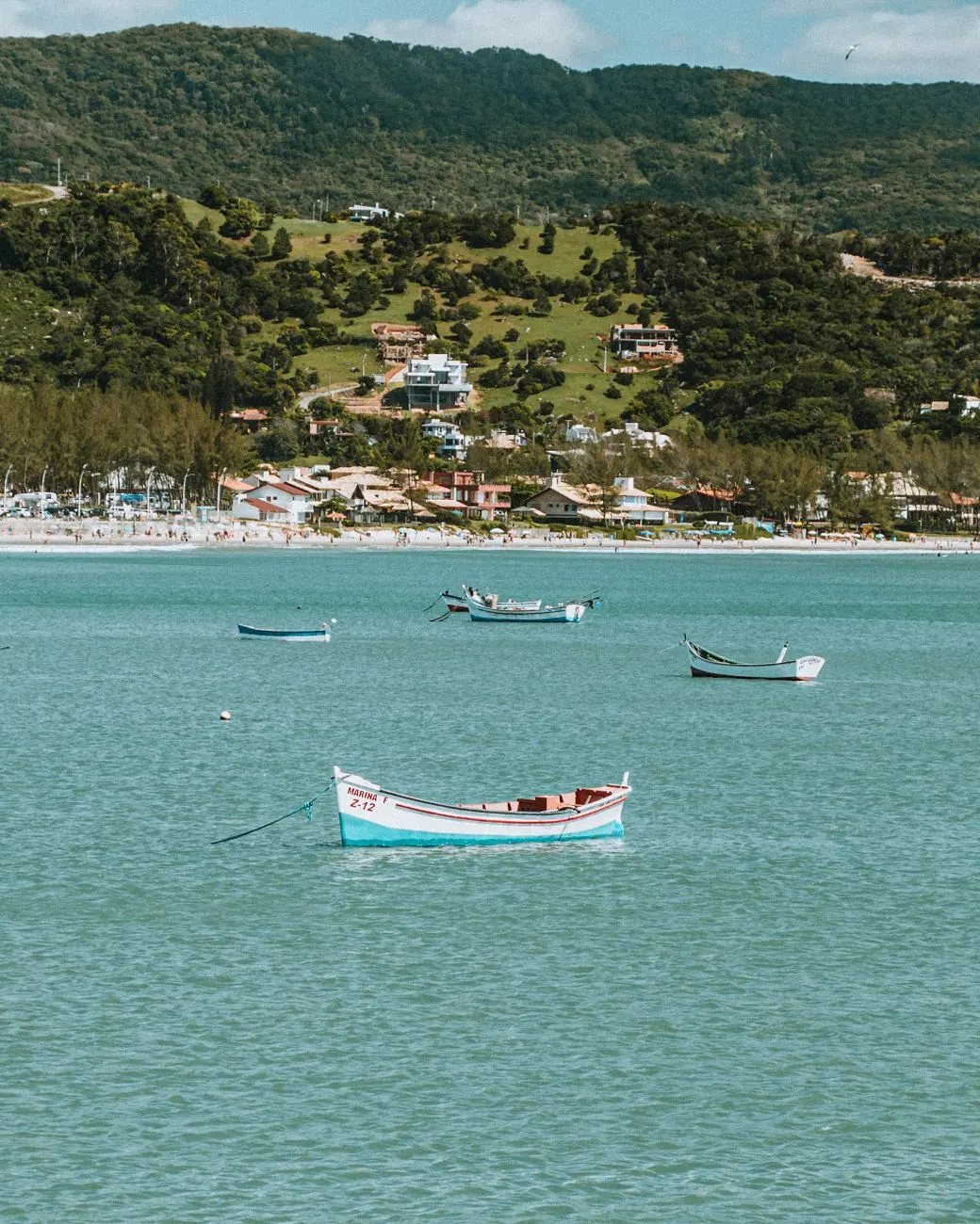 Barcos na baía de Garopaba com o morro ao fundo