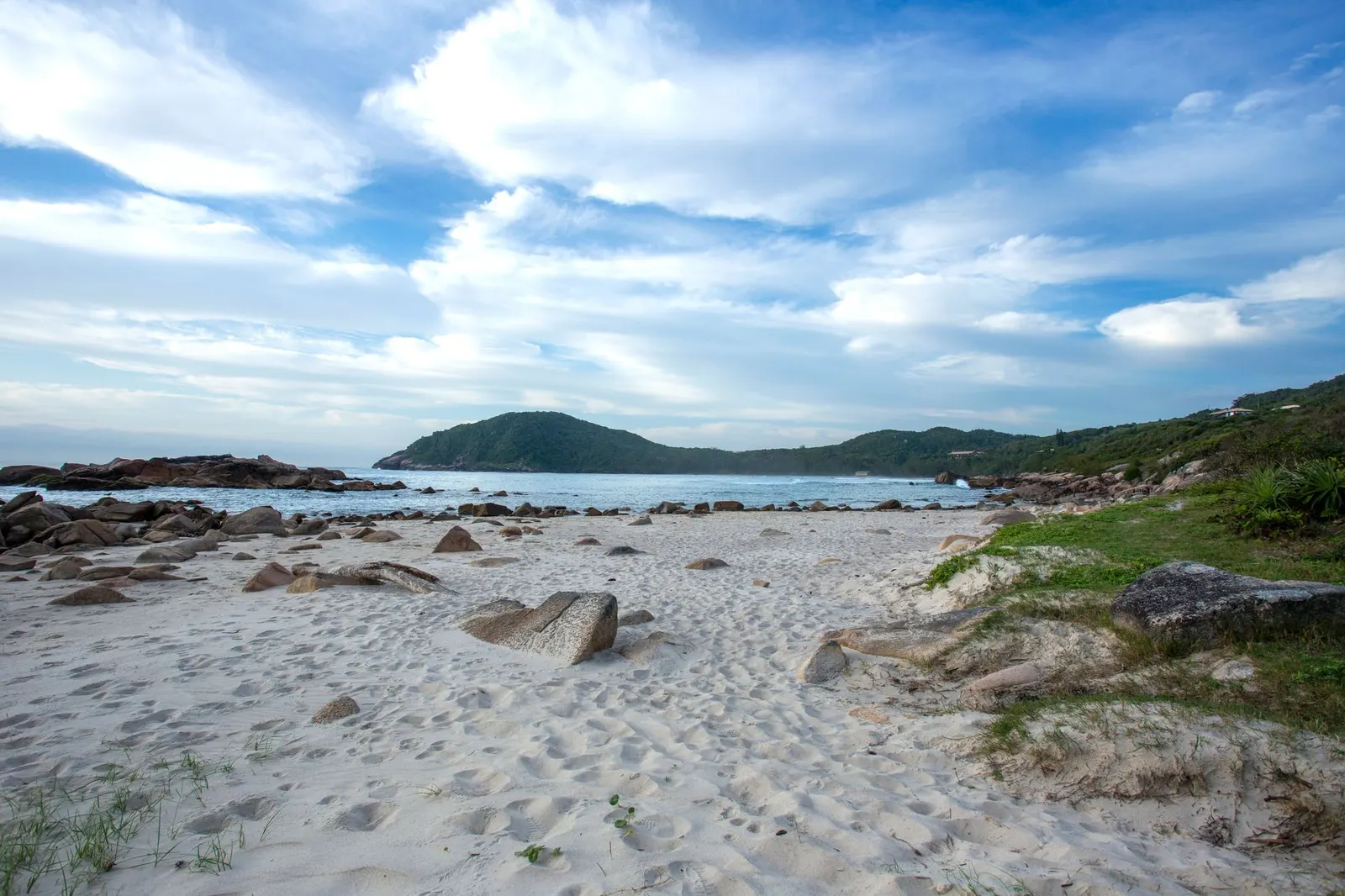 Praia com pedras e céu nublado em Garopaba